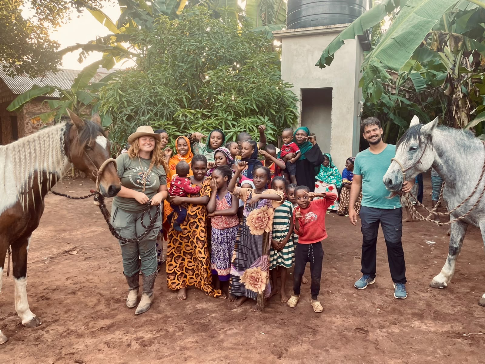 Anna and Daniel with two horses and children in a Zanzibar village