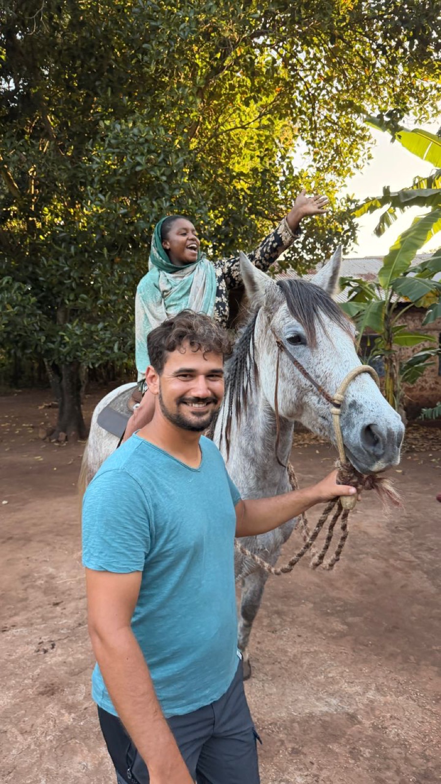 A girl on the horse waving with joy